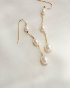 A dramatic cascade of pearls to dress up or down—from jeans and a tee to an evening gown. Starring three lit-from-within freshwater pearls (and a super comfy, elegant ear wire!) for an effortless glow wherever you go. Sold as a pair. As with any pearl piece, we recommend keeping away from harsh cleansers and beauty products, wearing them often, storing them in linen or cloth (no airtight containers) and gently wiping to clean so they'll stay lustrous forever. For more pearl care tips, check out Formal Linear Drop Earrings With Pearl Charm, White Pearl Drop Linear Earrings In 14k Gold Filled, Formal Teardrop Linear Earrings With Pearl Charm, Handmade 14k Gold Filled Dangle Pearl Earrings, Party Pearl Charm Linear Drop Earrings, White 14k Gold Filled Pearl Drop Linear Earrings, Gold Teardrop Linear Earrings With Pearl Charm, Yellow Gold Pearl Chain Teardrop Earrings, 14k Gold-filled Yellow Gold Pearl Drop Earrings