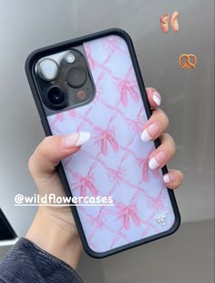 a woman holding up her phone case with pink flowers on the front and back cover