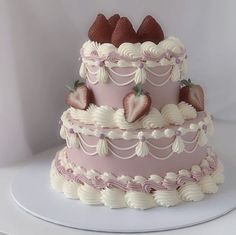a three tiered cake with strawberries on the top and white icing around it