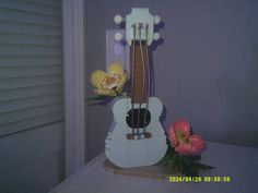 a white guitar with flowers on top of it