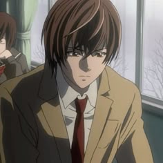 a man in a suit and tie standing next to another man wearing a brown jacket