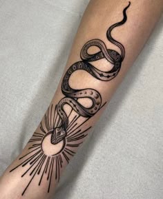 a black and white snake tattoo on the arm