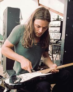 a man with long hair is playing an electric guitar