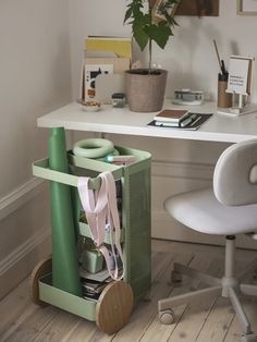 a desk with a chair, plant and other office supplies on it's side