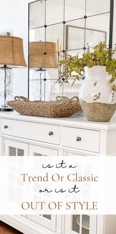 a white dresser topped with a mirror and vase filled with flowers on top of it