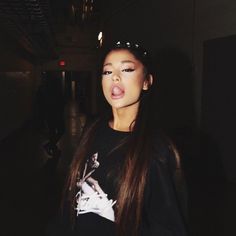 a woman with long hair sticking out her tongue