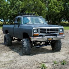 a black truck parked on top of a dirt field