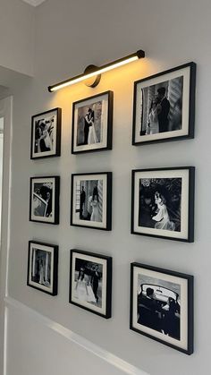 black and white photographs hanging on the wall in a room with light coming from above