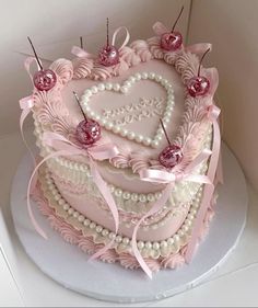 a heart shaped cake decorated with pearls and bows