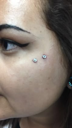 a woman with piercings on her nose looking at the camera