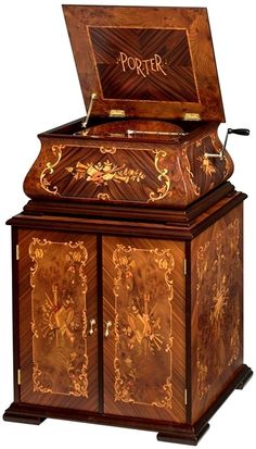 an ornately decorated wooden box with writing on the lid and bottom, sitting upright