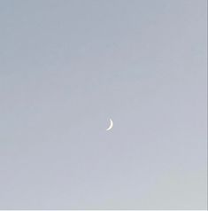 an airplane flying in the sky with a half moon on it's left side