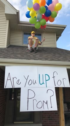a sign that says are you up for prom? on the roof of a house