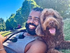 a man is smiling while holding his dog
