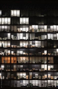 an office building at night with lots of windows lit up by the lights on it