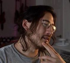 a man with glasses is brushing his teeth