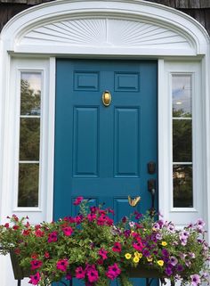 a blue front door with flowers in the window box