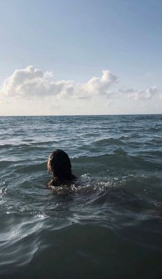 a person is swimming in the ocean with their head above the water's surface