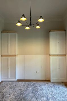an empty room with white walls and cabinets
