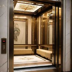 an elevator with two benches and paintings on the wall behind it in a hotel lobby
