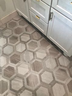 a kitchen floor with hexagonal tiles in grey and white colors on the floor