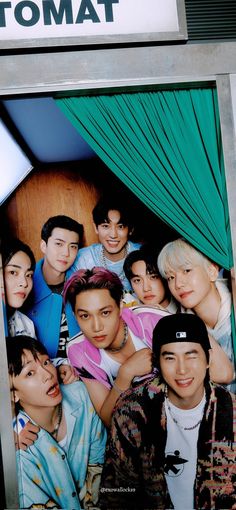 a group of young men standing next to each other in front of a sign that says tamote