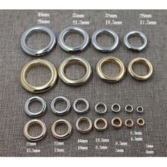 an assortment of metal rings and washers on a gray background with measurements for each ring