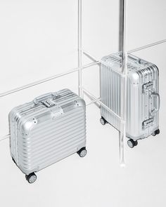 two silver suitcases sitting next to each other