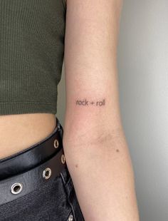 a woman's arm with the word rock and roll tattooed on her left arm