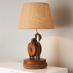 a lamp that is sitting on top of a table next to a white dresser with drawers