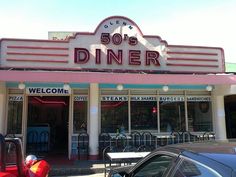 an old diner with tables and chairs in front of the restaurant's sign that reads 50's diner