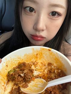 a woman is holding a bowl of food