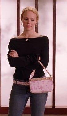 a woman standing with her arms crossed holding a pink purse