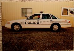 a police car is parked in front of a building with a window on the side