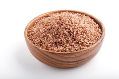 a wooden bowl filled with brown rice