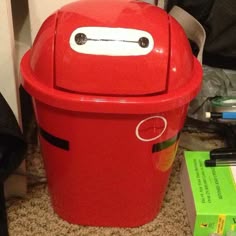 a red trash can sitting on the floor