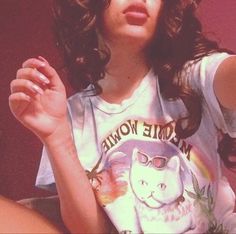a woman with long dark hair wearing a t - shirt that has a cat on it