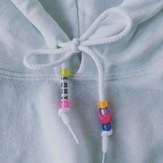 a white hoodie with colorful beads attached to it