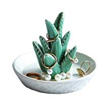 a white bowl filled with green plants and pearls