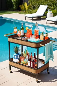 an outdoor bar cart with drinks on it next to a swimming pool