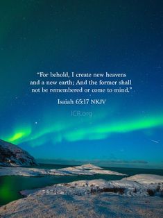 the sky with green and blue lights above it is in front of some snow covered hills