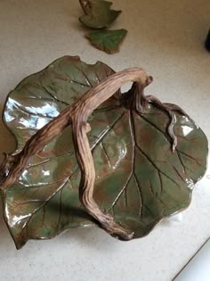 a green leaf shaped dish sitting on top of a counter