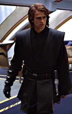 a young man dressed as luke sky walker is walking in front of a star wars vehicle