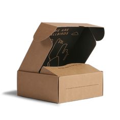 an open cardboard box with a hand drawn on the front and inside, sitting on a white surface