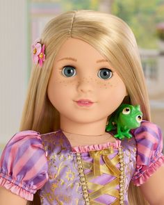 a close up of a doll with a frog on her shoulder