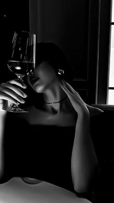 a woman sitting on a couch holding a glass of wine in front of her face