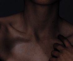 a man with no shirt on is holding his hand up to his chest and looking at the camera