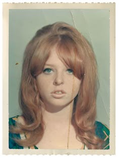 an old photo of a woman with red hair and blue eyes wearing a green dress