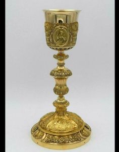 an ornate gold colored cup on a stand