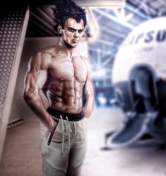 a man standing in front of an airplane with his hands on his hips and looking at the camera